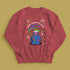 A holiday sweatshirt featuring a cute Grim Reaper holding a scythe, wearing a Santa hat. Above the character is the text "Grave Tidings We Bring," surrounded by festive snowflakes and holiday-themed designs. The combination of spooky and festive elements adds a humorous twist to traditional holiday attire.